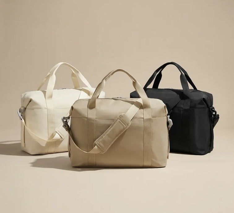 Three bags in beige, cream, and black on a beige background